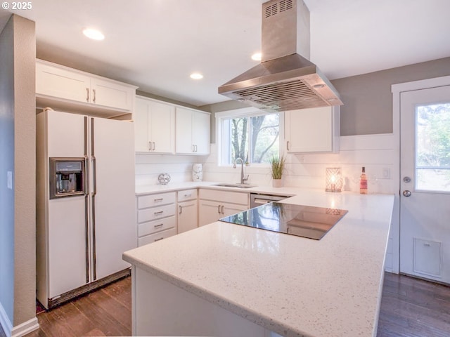 kitchen with island range hood, a sink, a peninsula, dark wood-style floors, and white fridge with ice dispenser
