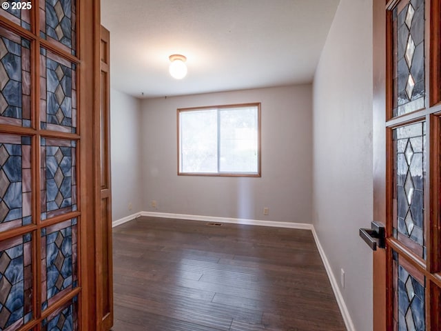 interior space featuring baseboards and dark wood-style flooring