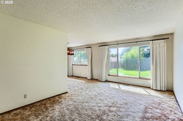 13230 SW Hill Ct, Portland, OR 97223 - spare room with a textured ceiling, carpet, baseboards, and a notable chandelier