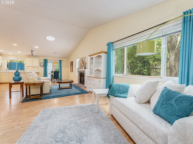 1761 SW Songbird St, Mcminnville, OR 97128 - living room featuring plenty of natural light, a fireplace with raised hearth, light wood-style flooring, vaulted ceiling, and recessed lighting