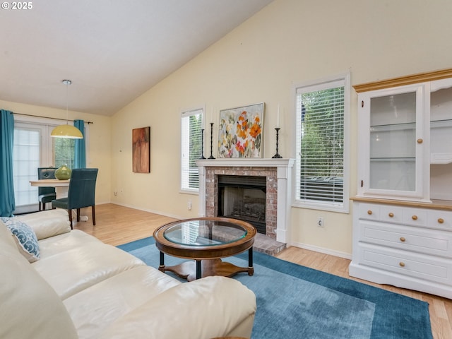 1761 SW Songbird St, Mcminnville, OR 97128 - living area featuring wood finished floors, a brick fireplace, plenty of natural light, and high vaulted ceiling