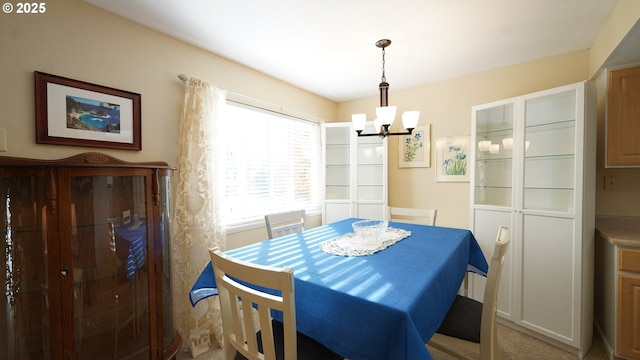 carpeted dining room with an inviting chandelier