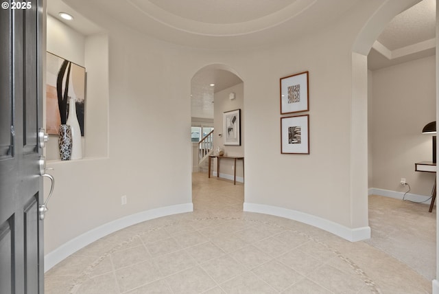 entryway featuring light tile patterned floors and a raised ceiling