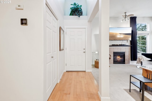 hall featuring a towering ceiling and light hardwood / wood-style floors