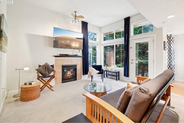 living room featuring light carpet, a fireplace, and ceiling fan