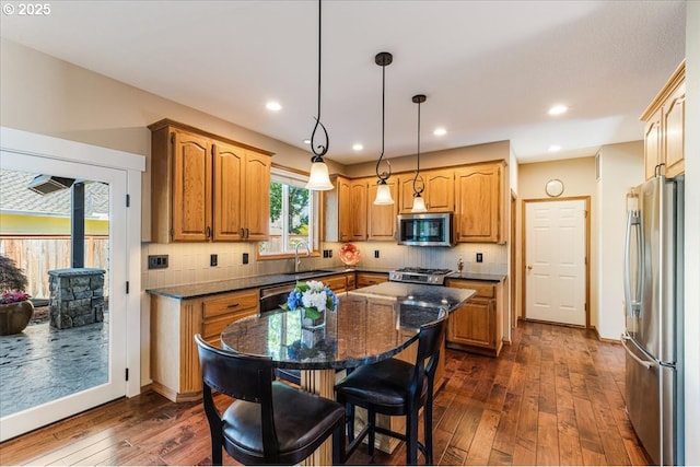 16706 NW Waterford Way, Portland, OR 97229 - kitchen with stainless steel appliances, a kitchen island, dark wood finished floors, tasteful backsplash, and recessed lighting