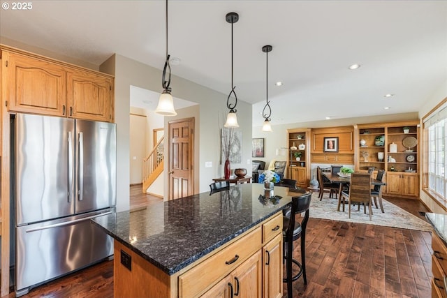 16706 NW Waterford Way, Portland, OR 97229 - kitchen with freestanding refrigerator, dark wood finished floors, a breakfast bar area, dark stone counters, and a center island