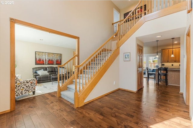 16706 NW Waterford Way, Portland, OR 97229 - stairway featuring hardwood / wood-style flooring, a towering ceiling, and baseboards