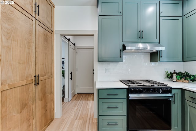 2110 Labona Dr, Eugene, OR 97404 - kitchen with black range with gas stovetop, under cabinet range hood, green cabinetry, and a barn door