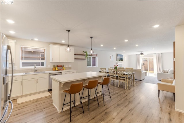 456 Cornwell St, Woodburn, OR 97071 - kitchen featuring stainless steel appliances, a kitchen island, white cabinetry, a kitchen breakfast bar, and light countertops