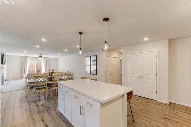 456 Cornwell St, Woodburn, OR 97071 - kitchen with light wood-style flooring, a kitchen island, recessed lighting, white cabinets, and a kitchen bar