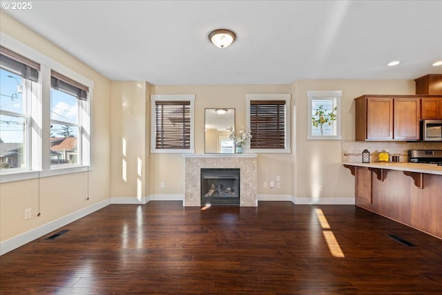 unfurnished living room with dark wood-type flooring and a tiled fireplace