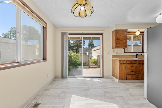 110 NE Village Squire Ave Unit 12, Gresham, OR 97030 - doorway featuring a sink, baseboards, and a textured ceiling