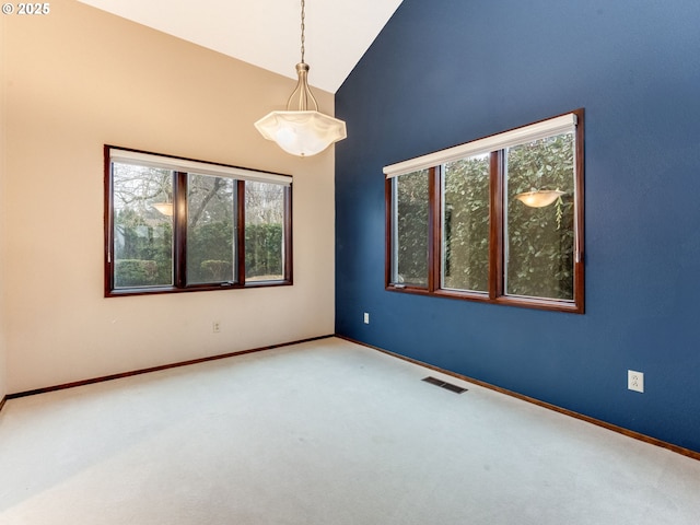 spare room with high vaulted ceiling, carpet, visible vents, and baseboards