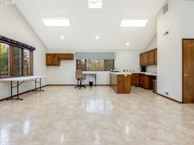 kitchen with brown cabinets, a wealth of natural light, light countertops, and visible vents