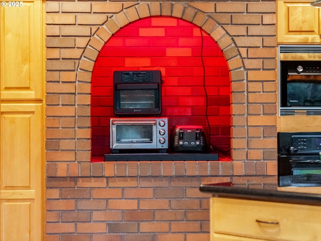 kitchen with black oven and brick wall