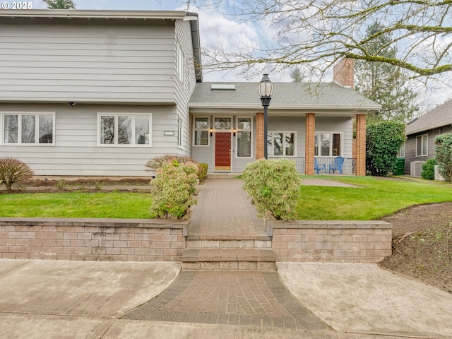 view of front facade featuring covered porch, central AC, a front lawn, and a chimney