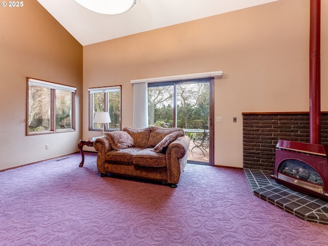 living room featuring a wood stove, high vaulted ceiling, and carpet floors