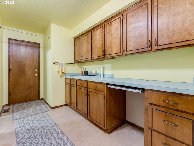 kitchen with light countertops, visible vents, and brown cabinets