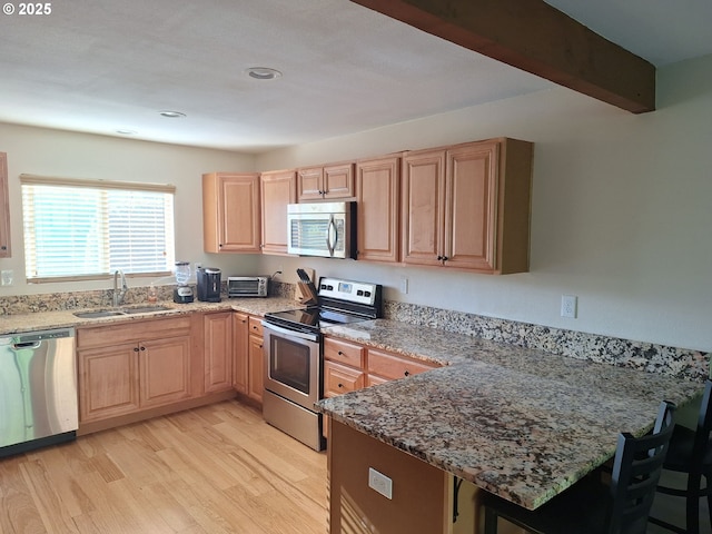 4777 Exeter St, West Linn, OR 97068 - kitchen with stainless steel appliances, a sink, light wood-style flooring, a peninsula, and light brown cabinetry