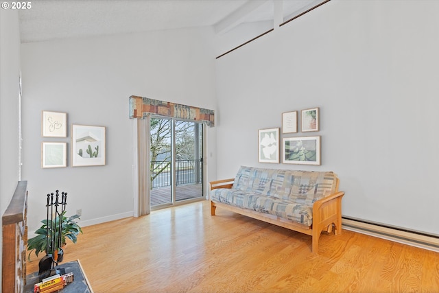 sitting room with baseboards, a baseboard radiator, wood finished floors, beamed ceiling, and high vaulted ceiling