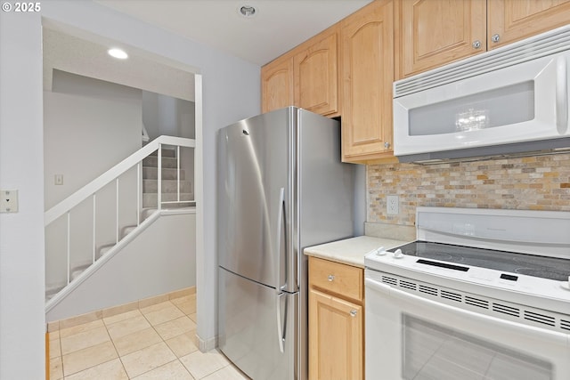 kitchen featuring light tile patterned floors, white appliances, light countertops, backsplash, and light brown cabinetry