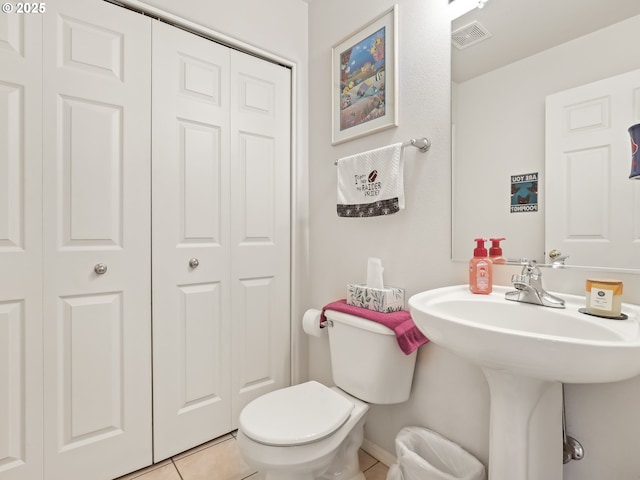 bathroom featuring toilet, tile patterned floors, visible vents, and a closet