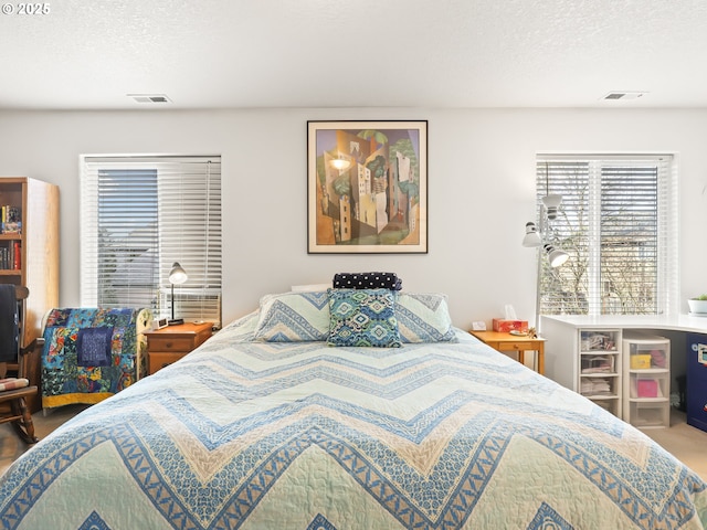 bedroom featuring a textured ceiling and visible vents