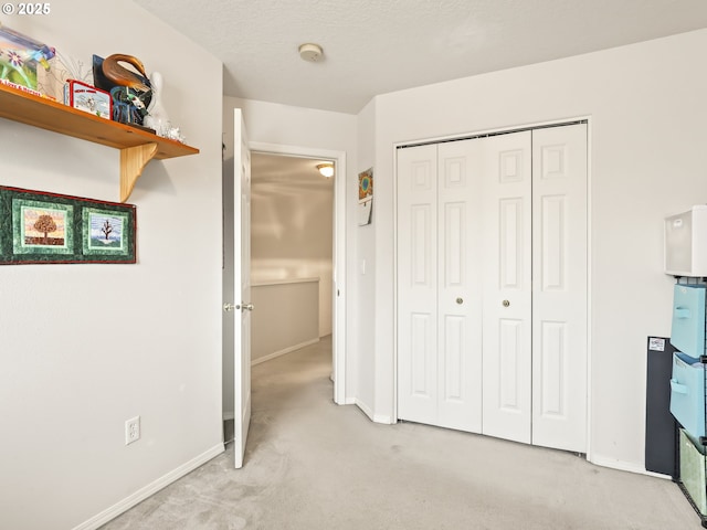 unfurnished bedroom with light colored carpet, baseboards, and a closet