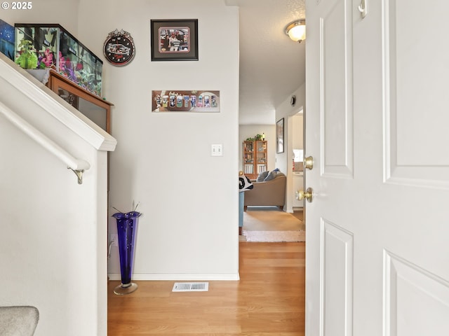 interior space featuring visible vents, baseboards, and wood finished floors