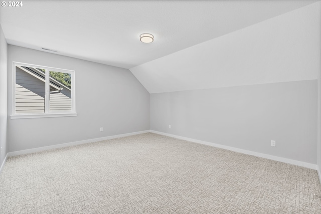 additional living space with vaulted ceiling, carpet floors, and baseboards