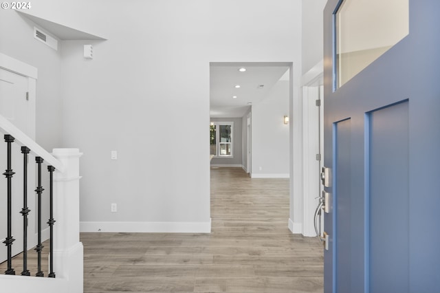 foyer entrance with light wood finished floors, visible vents, baseboards, stairs, and recessed lighting