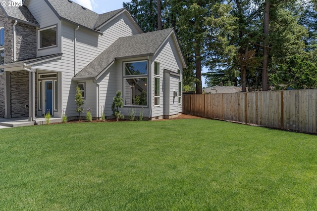 view of side of home with a yard