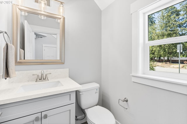 bathroom with visible vents, vanity, and toilet