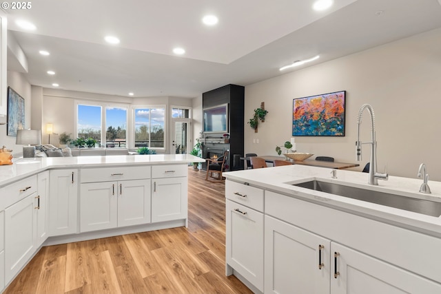 kitchen featuring sink, white cabinets, and light hardwood / wood-style flooring