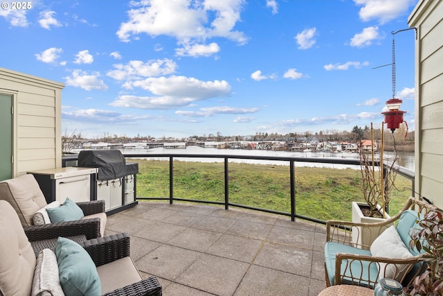 balcony with a water view and grilling area