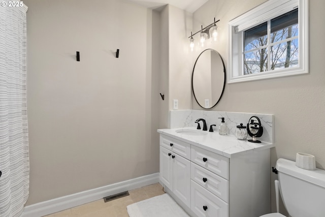 bathroom featuring vanity, tile patterned floors, and toilet