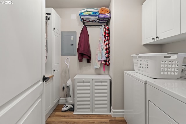 washroom with cabinets, electric panel, light hardwood / wood-style floors, and washer and dryer