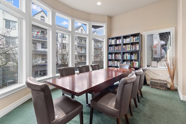 dining space featuring dark colored carpet and a wealth of natural light