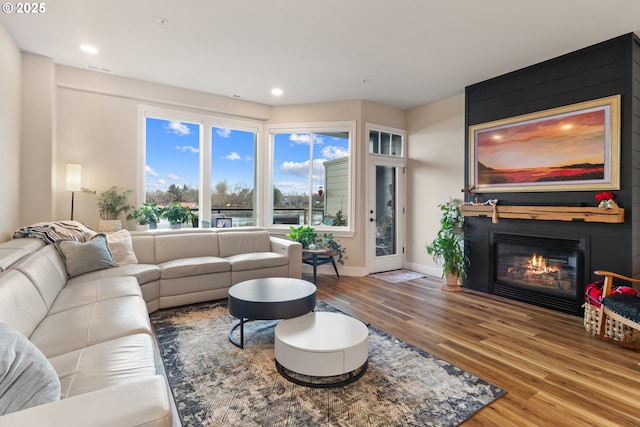 living room featuring a large fireplace and hardwood / wood-style floors