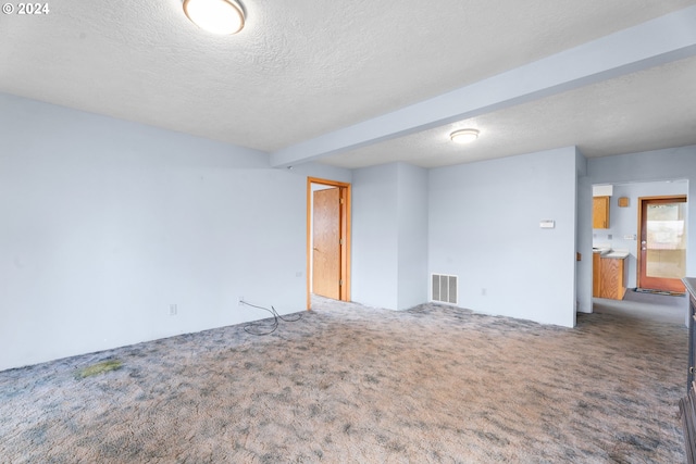 carpeted empty room featuring a textured ceiling