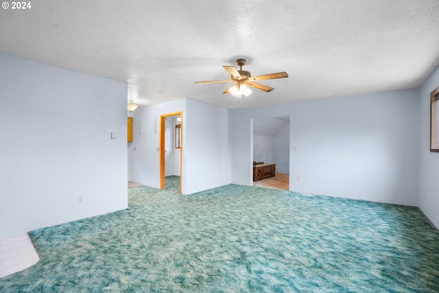 empty room featuring a ceiling fan, carpet floors, and a textured ceiling