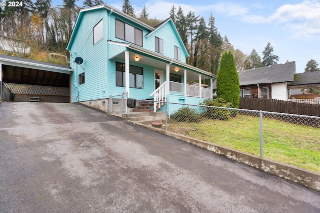 view of front of property with covered porch, asphalt driveway, and a detached carport