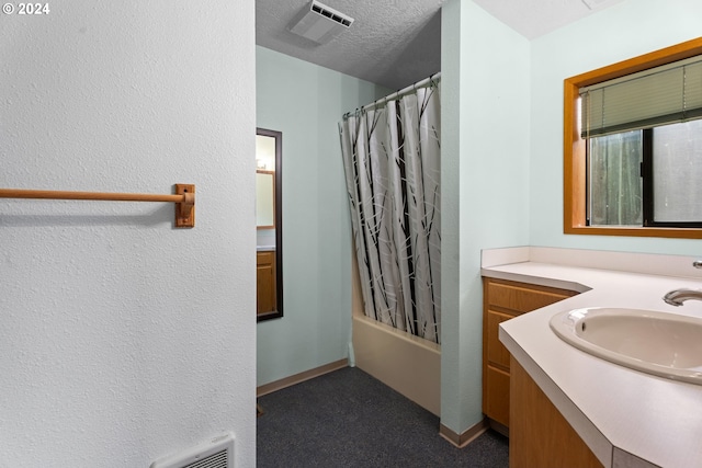 full bathroom featuring vanity, shower / bath combo, and a textured wall