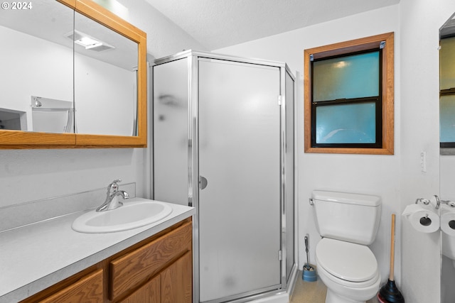 bathroom with a shower stall, toilet, and vanity