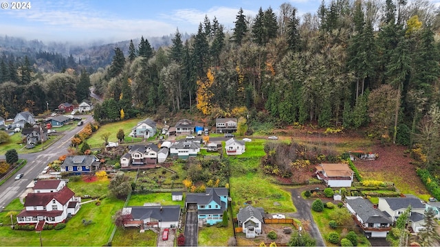 aerial overview of property's location featuring nearby suburban area and a heavily wooded area