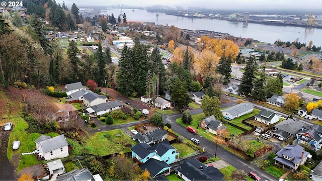 aerial view of property and surrounding area featuring a nearby body of water, a notable bridge, and nearby suburban area