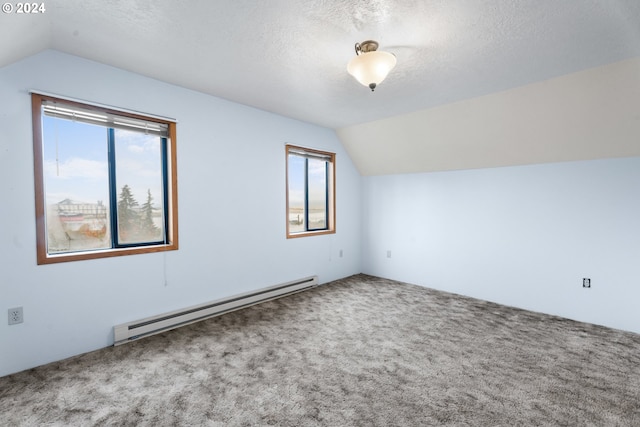 bonus room featuring a baseboard heating unit, vaulted ceiling, carpet floors, and a textured ceiling