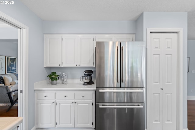 5346 NW Wickiup Way, Portland, OR 97229 - kitchen with freestanding refrigerator, white cabinetry, light countertops, and wood finished floors
