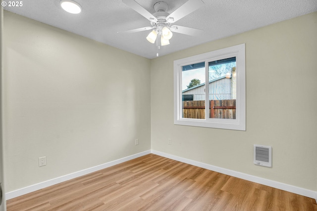 empty room featuring ceiling fan, a textured ceiling, and light wood-type flooring